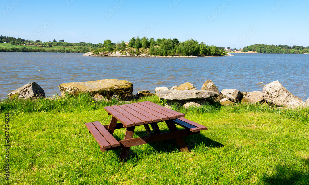 A wooden picnic table with benches at the shore of Halandsvatnet lake, Stavanger, Norway, May 2018