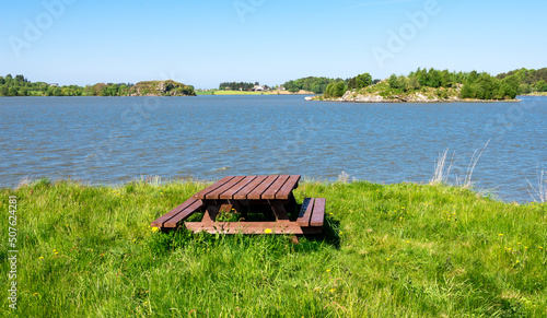 Obraz na płótnie A wooden picnic table with benches on a small grass lawn at Halandsvatnet lake, Stavanger, Norway, May 2018 w salonie