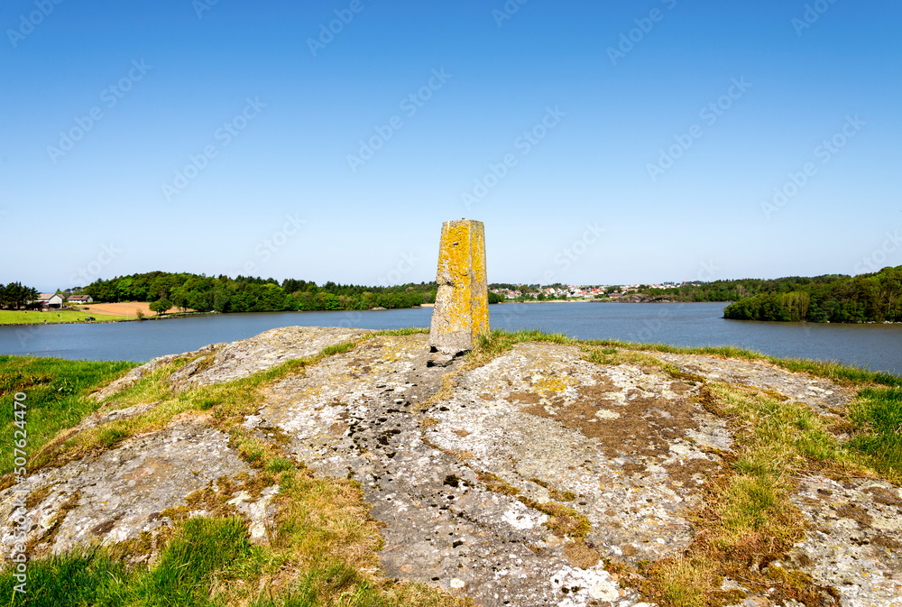 A view to Halandsvatnet lake coastline from a small hill with an old stone post, Stavanger, Norway, May 2018