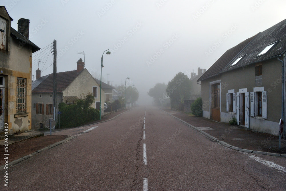 View of Old French Village Buildings and Road on Misty Morning