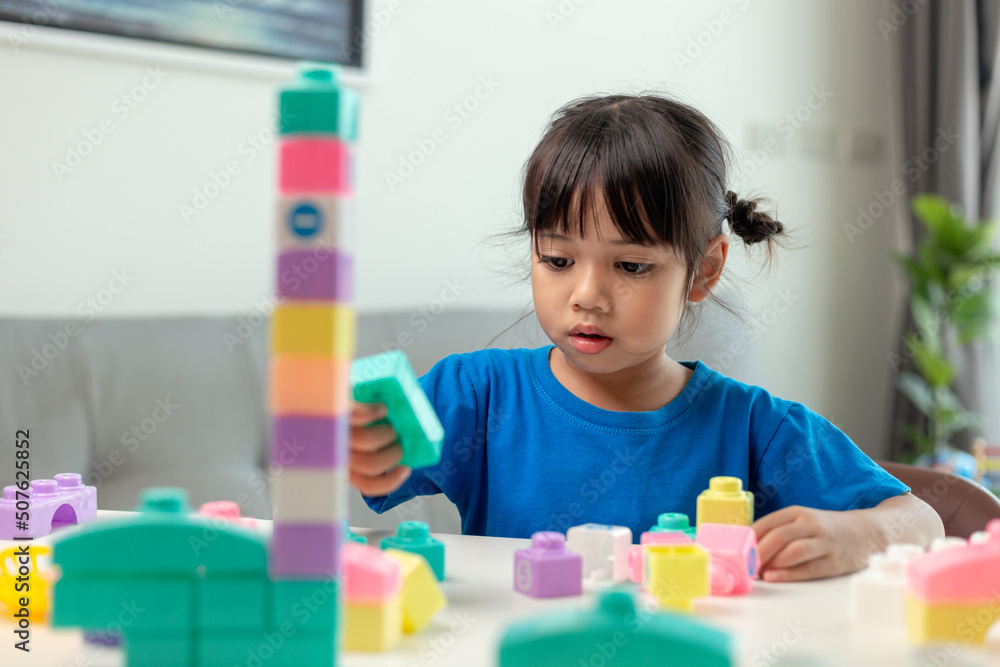 Adorable little girl playing toy blocks in a bright room Adorable little girl playing toy blocks in a bright room