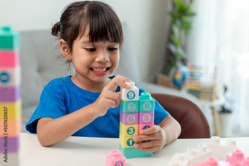 Adorable little girl playing toy blocks in a bright room Adorable little girl playing toy blocks in a bright room