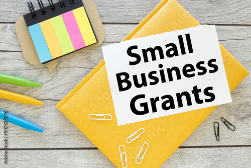 Small Business Grants. page with an inscription and a yellow diary. inscription on a notebook near a calculator and bright stickers