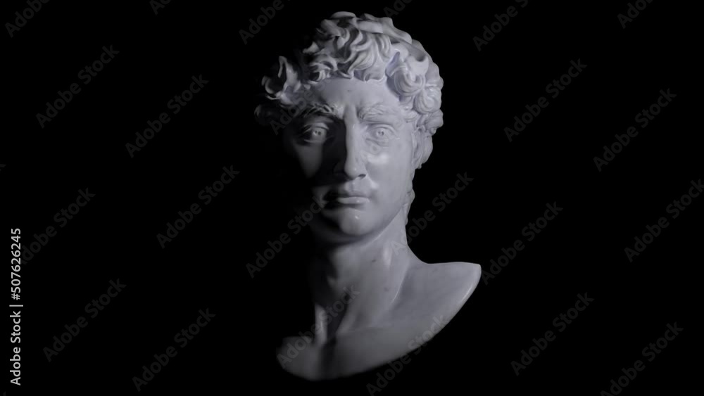 4K loop rendering animation of light and shade dramatic illustration from 3d rendering of classical white marble male head bust looking straight and illuminated by a theatrical light source. 4K loop rendering animation of light and shade dramatic illustration from 3d rendering of classical white marble male head bust looking straight and illuminated by a theatrical light source.