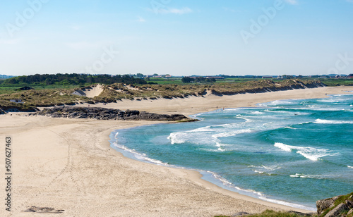 Fototapeta Naklejka Na Ścianę i Meble -  A view to long beautiful Hellestostranden sand beach  and surrounding area with green hills and fields near Stavanger city, Norway, May 2018