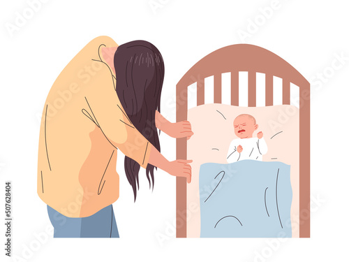 Woman suffering from postpartum depression standing at the crib