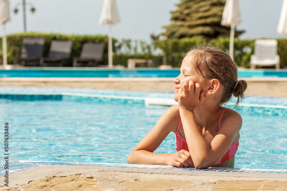 Pool For Children at Sea Beach. Sunbathing girl in resort pool. Child enjoy Summer Vacation at Sea.