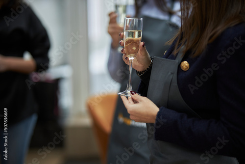 girl holding a glass of champagne in her hands at a party, close-up