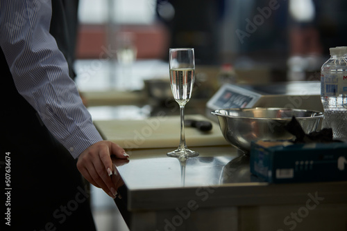 a glass of champagne on the table close-up, and the hand of the cook