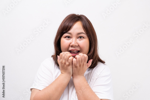 Young beautiful Asian oversize women smile with positive emotion, feeling happy and proud with her body size. Portrait shot on white background with copy space.