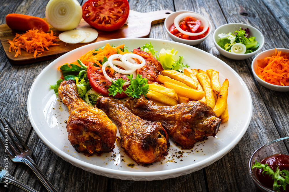 Barbecue chicken drumsticks with chips and greens on wooden table
Barbecue chicken drumsticks with chips and greens on wooden table