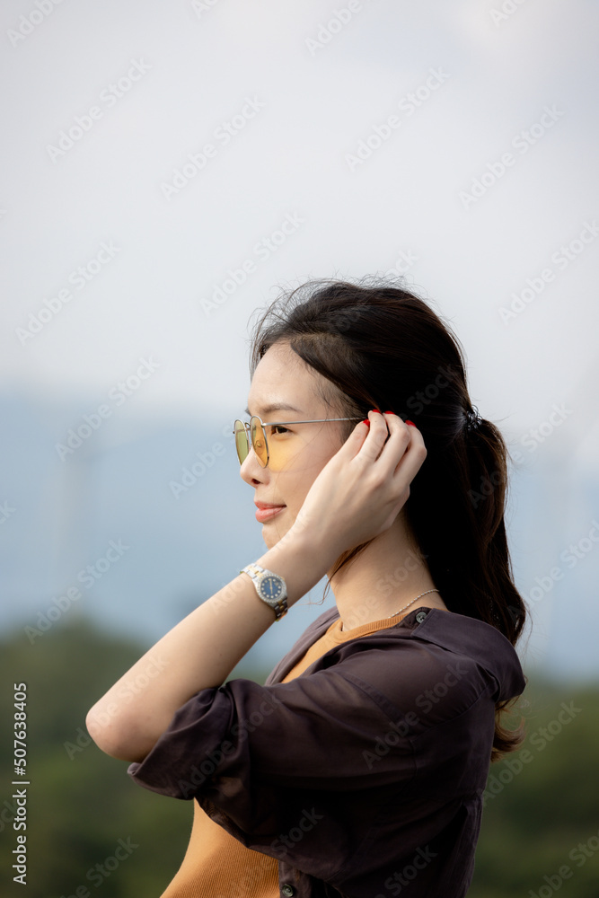 cute girl standing and playing with beautiful nature with clear sky on vacation They stood and took pictures happily.