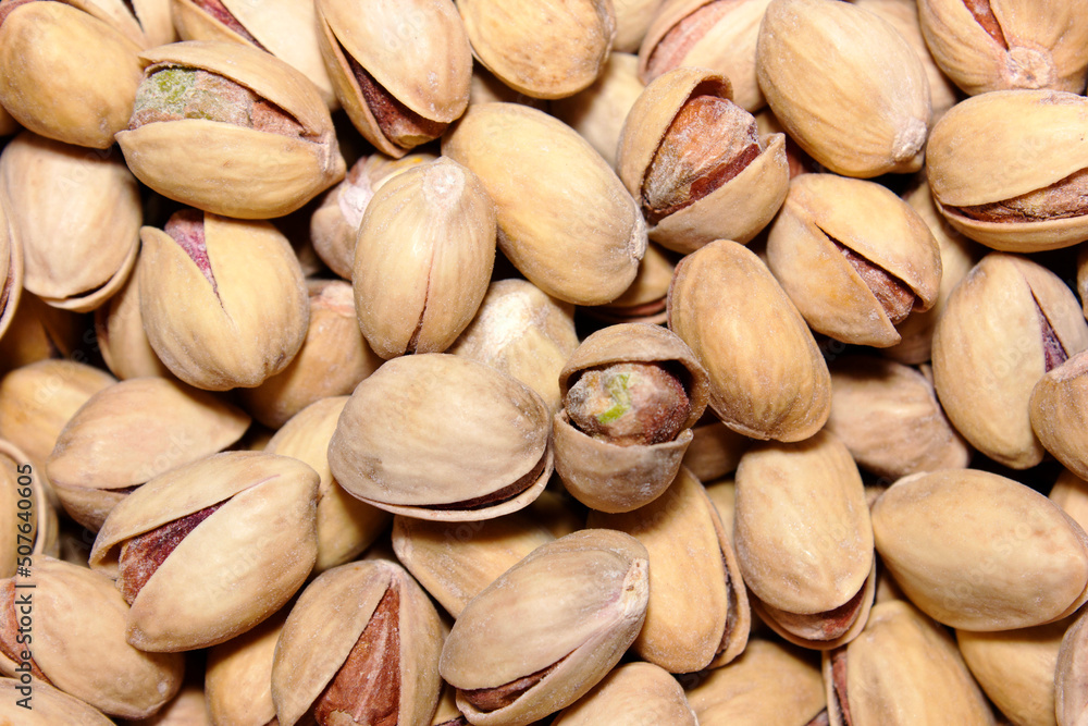 Pistachios texture and background . Tasty pistachios as background,as pistachios texture. flat lay. Nuts. A healthy snack. Vitamins and proteins. Nuts in the shell.