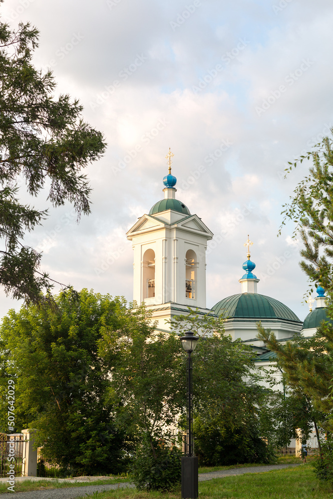 A large white church with blue domes and golden crosses,.