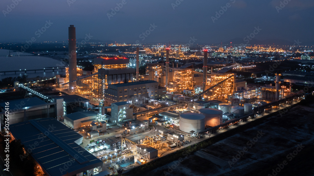 Aerial view coal power plant station at night, Power plant and coal storage heavy industrial coal powered electricity plant with pipes and smoke.