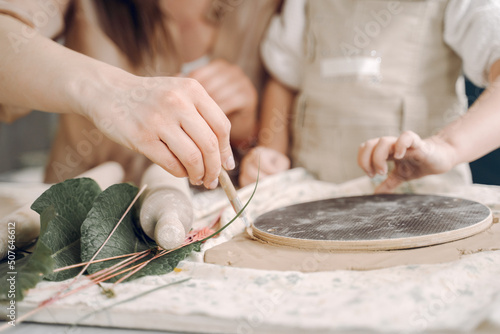 Portrait of mother and little girl shaping clay together