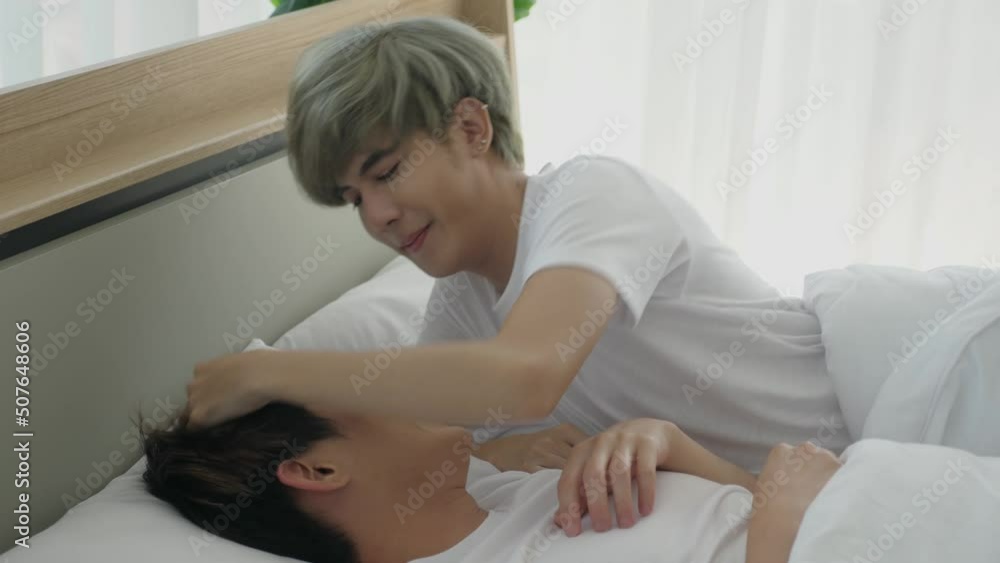young-asian-gay-couple-teasing-in-bed-kissing-touching-hair-patting