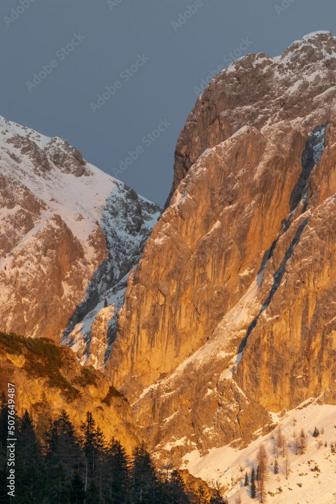 snow covered rocks in the dolomites during sunset