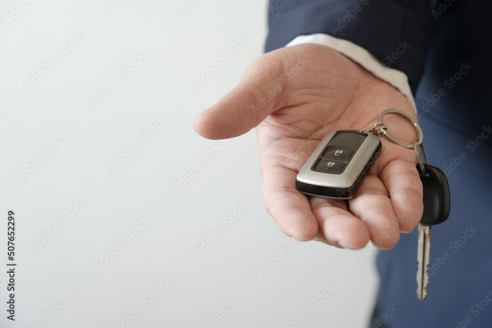 Businessman holding car key concept of buy new vehicle car. Giving car key to customer or car rental service. Businessman holding car key concept of buy new vehicle car. Giving car key to customer or car rental service.