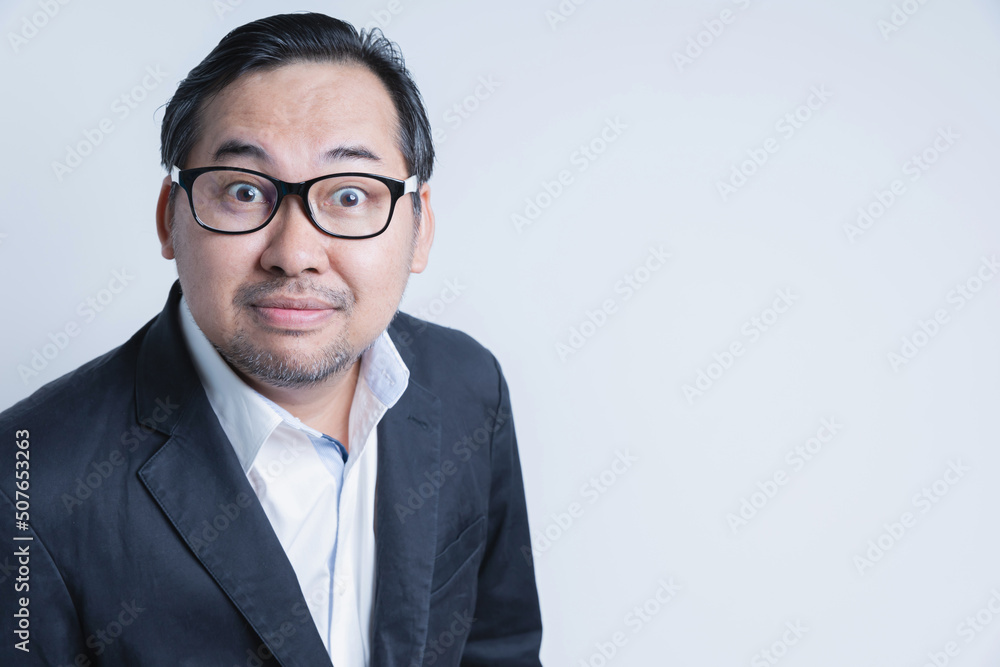 Portrait Asian businessman wearing a suit and wearing eyewear stands smiling happy looking at the camera on white background with copy space. Business, financial, and leadership.