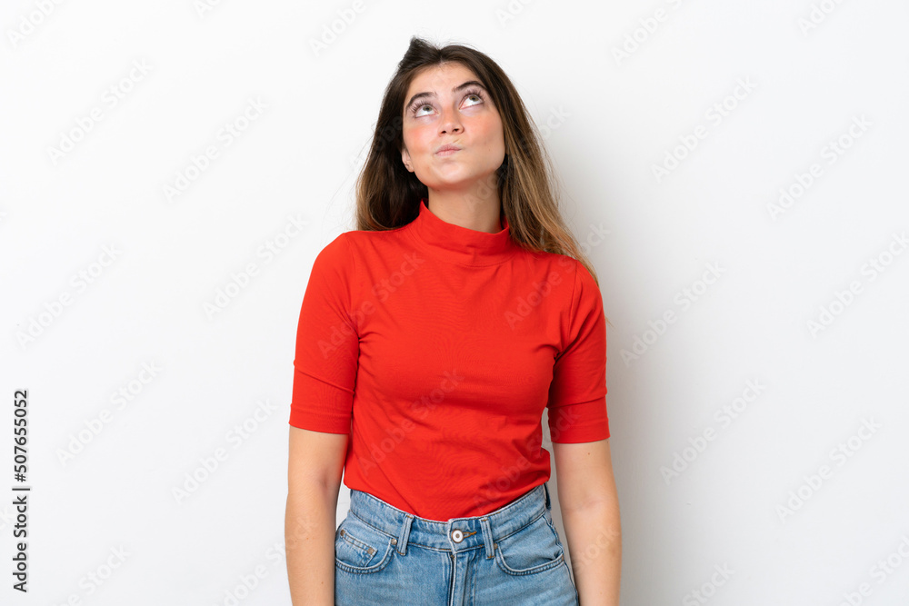 Young caucasian woman isolated on white background and looking up Young caucasian woman isolated on white background and looking up