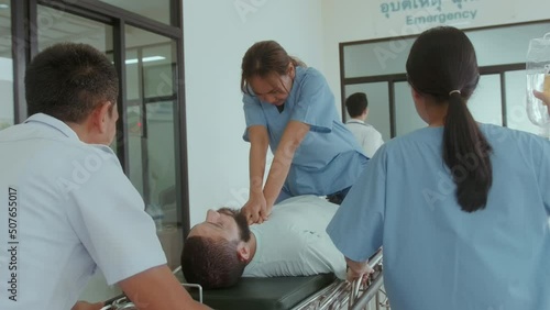 Group of rescue emergency team transporting patient from Emergency car  through Hospital Corridors. cardio pulmonary resuscitation on an unconscious patient .