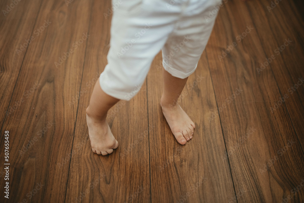 Barefoot boy on wooden floor background. Barefoot boy on wooden floor background.