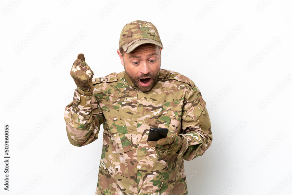 Military man isolated on white background surprised and sending a message Military man isolated on white background surprised and sending a message