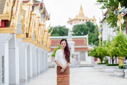 Portrait Asia woman wearing traditional dress of Thailand walking in temple for relaxation and meditation