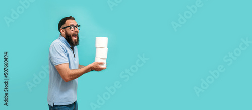 Photography Attractive young caucasian guy holds several rolls of toilet paper in his hands, toilet paper advertisement