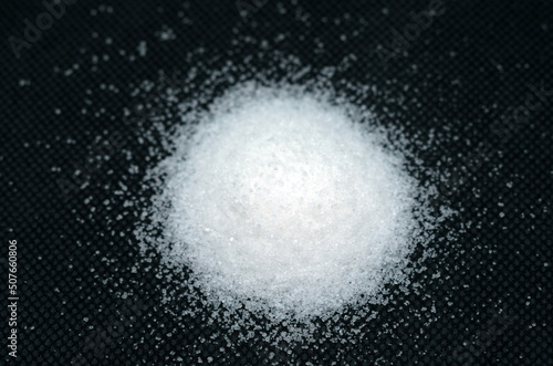 Small heap of sugar cut out against a black background