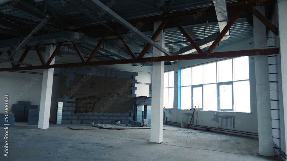 Repair work in empty room with large windows. Stock footage. Renovation in new empty room for company with steel beams and large Windows. White is placed under offices or warehouses