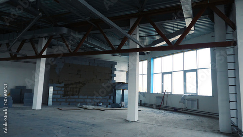 Repair work in empty room with large windows. Stock footage. Renovation in new empty room for company with steel beams and large Windows. White is placed under offices or warehouses