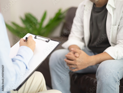 Psychotherapy consultation. Counselor talking to stress man, giving advice to young client. Friendly Asian woman psychologist having session with male customer.