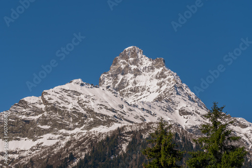 Snowy mountain peak against the blue winter sky. Mountain peak snow.