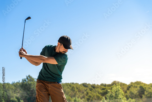 Young man playing golf in summer. Lifestyle game. Healthy and sporty outdoors. Concentration skills concept.