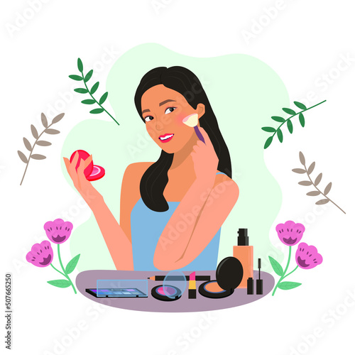 young woman doing her makeup on the cosmetic table.