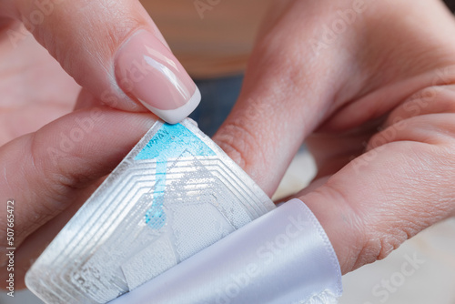 Obraz na płótnie Woman removing an electronic RFID device made for anti-theft purposes from clothing