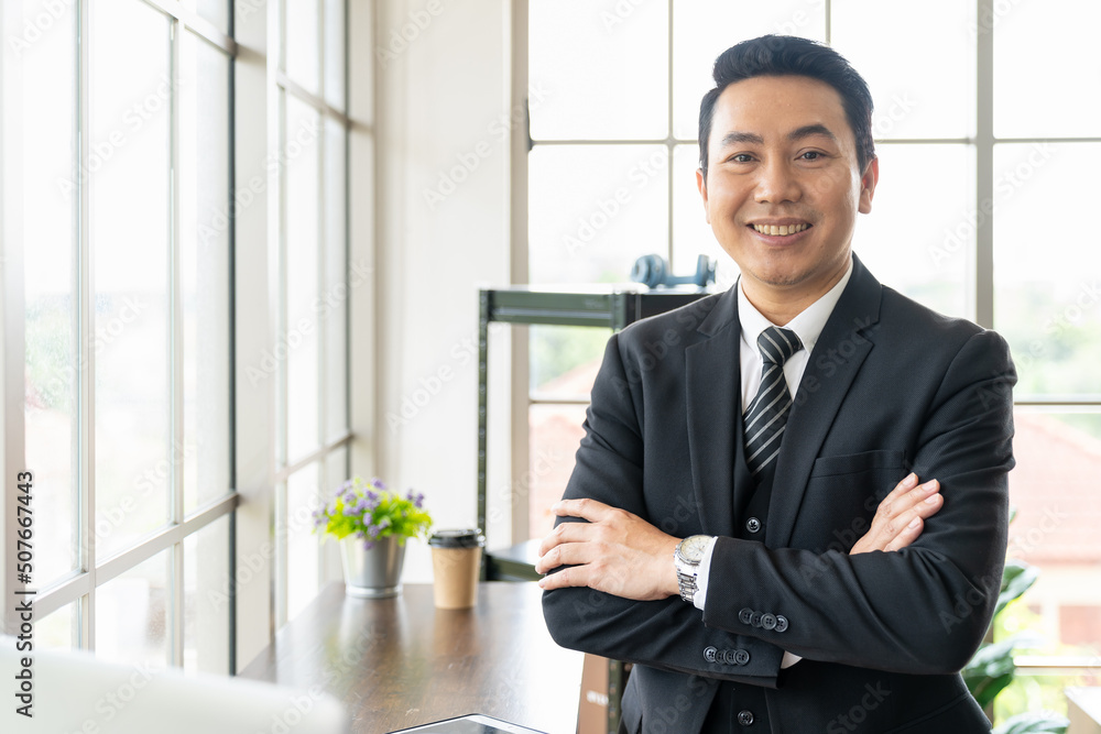 Close up of Asian executive business man wear suite at the workspace office. Happy Asian business man with laptop computer and background office Close up of Asian executive business man wear suite at the workspace office. Happy Asian business man with laptop computer and background office
