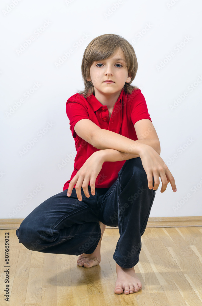 Portrait of cute kid sitting and putting hands on knee Portrait of cute kid sitting and putting hands on knee