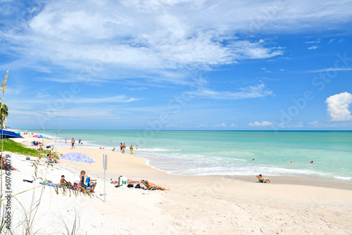 Fototapeta Naklejka Na Ścianę i Meble -  Tourists and locals relaxing on a beautiful, calm beach day in Vero Beach, Florida