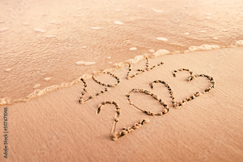 New Year 2023 replace 2022 on the sea beach concept. photo