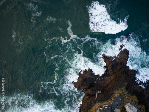 Shooting from a drone. Fascinating seascape. Turquoise sea water with white foamy waves and rocky shore. Picturesque corner of nature. There are no people in the photo. Ecology, geology.