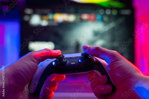 Close-up. The gamer holds a joystick in his hands. Plays video games on modern digital gaming equipment. Cyberspace, cybersport, game strategy, passion, excitement.