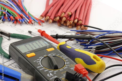 Multimeter and mounting tools in the electrical diagram close-up.
