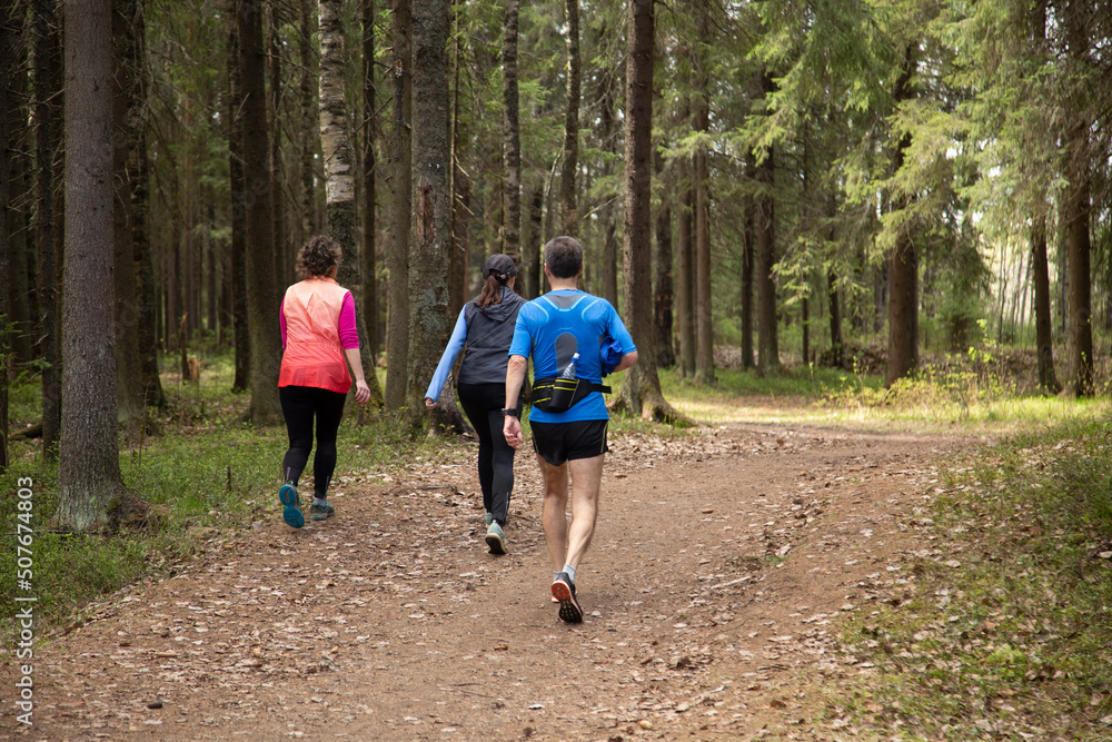 Man and women are running in a winter park. Doing sports in the park. Man and women are running in a winter park. Doing sports in the park.