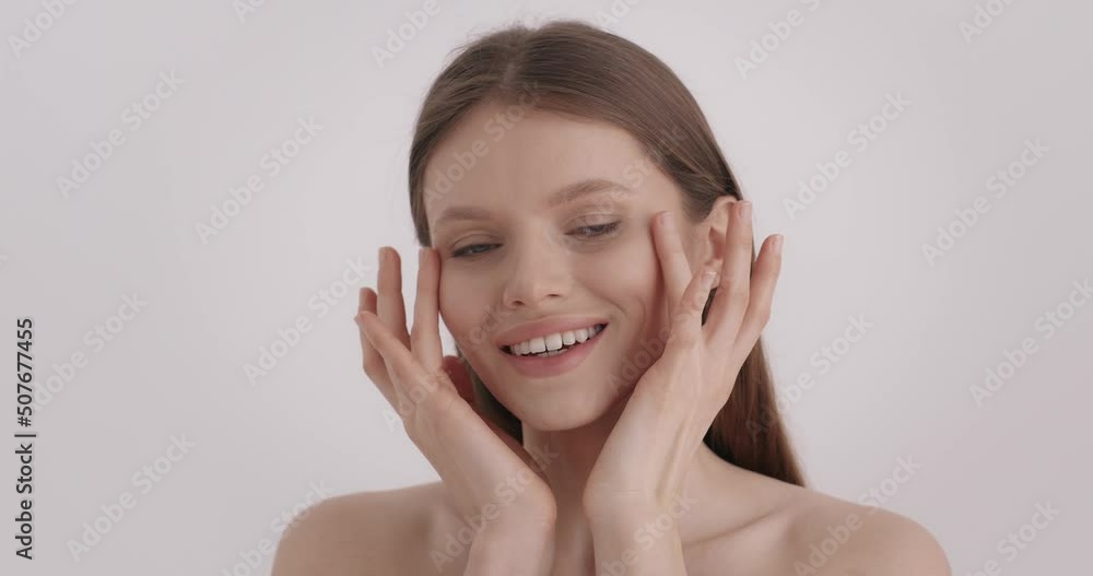 Skin care. Portrait of pleasant caucasian woman smiling and looking at camera while massaging with fingers under eyes zone. Beauty treatment and people concept. Skin care. Portrait of pleasant caucasian woman smiling and looking at camera while massaging with fingers under eyes zone. Beauty treatment and people concept.