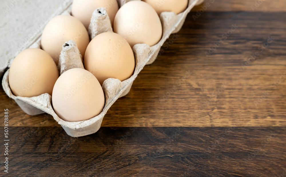 Ten chicken eggs in a cardboard tray on the table. Ten chicken eggs in a cardboard tray on the table.