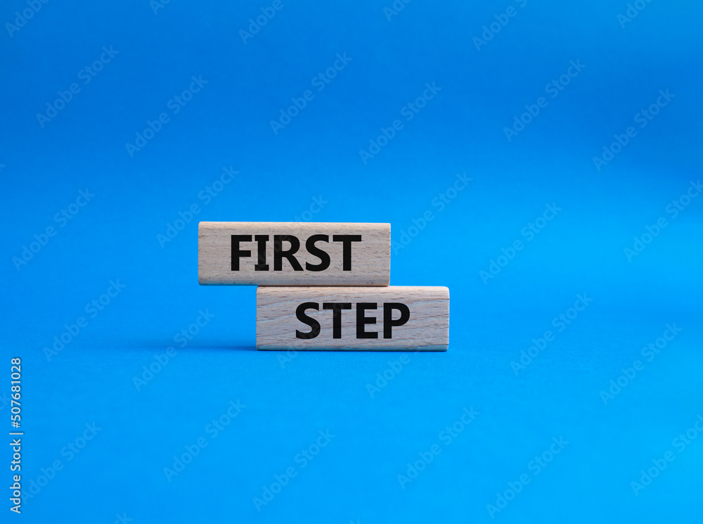 First step symbol. Wooden blocks with words 'First step'. Beautiful blue background. Business and 'First step' concept. Copy space. First step symbol. Wooden blocks with words 'First step'. Beautiful blue background. Business and 'First step' concept. Copy space.