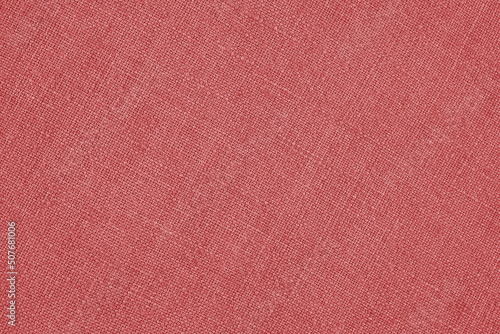 Light red woven surface close-up. Linen texture. Fabric background. Textured braided simple backdrop